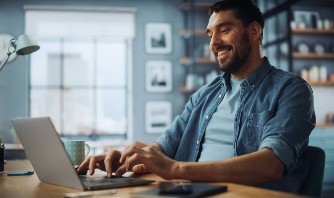 Mann arbeitet im Homeoffice am Notebook